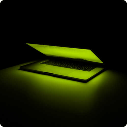 Glowing green half closed laptop.